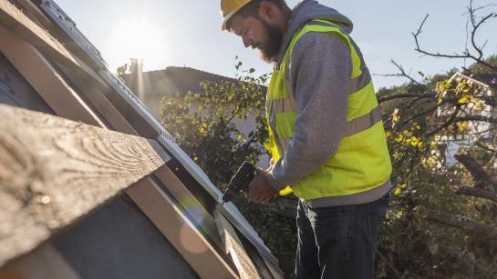 Man renoveert dak van een woning
